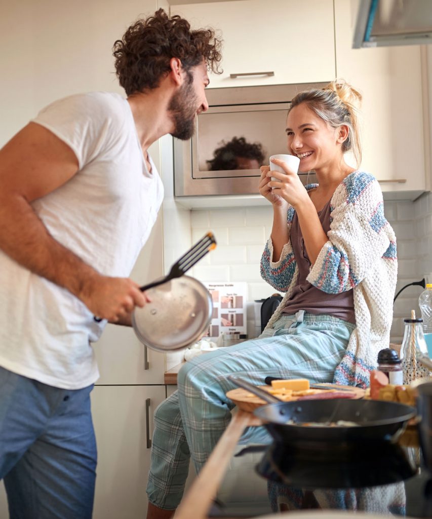 young couple cooking breakfast