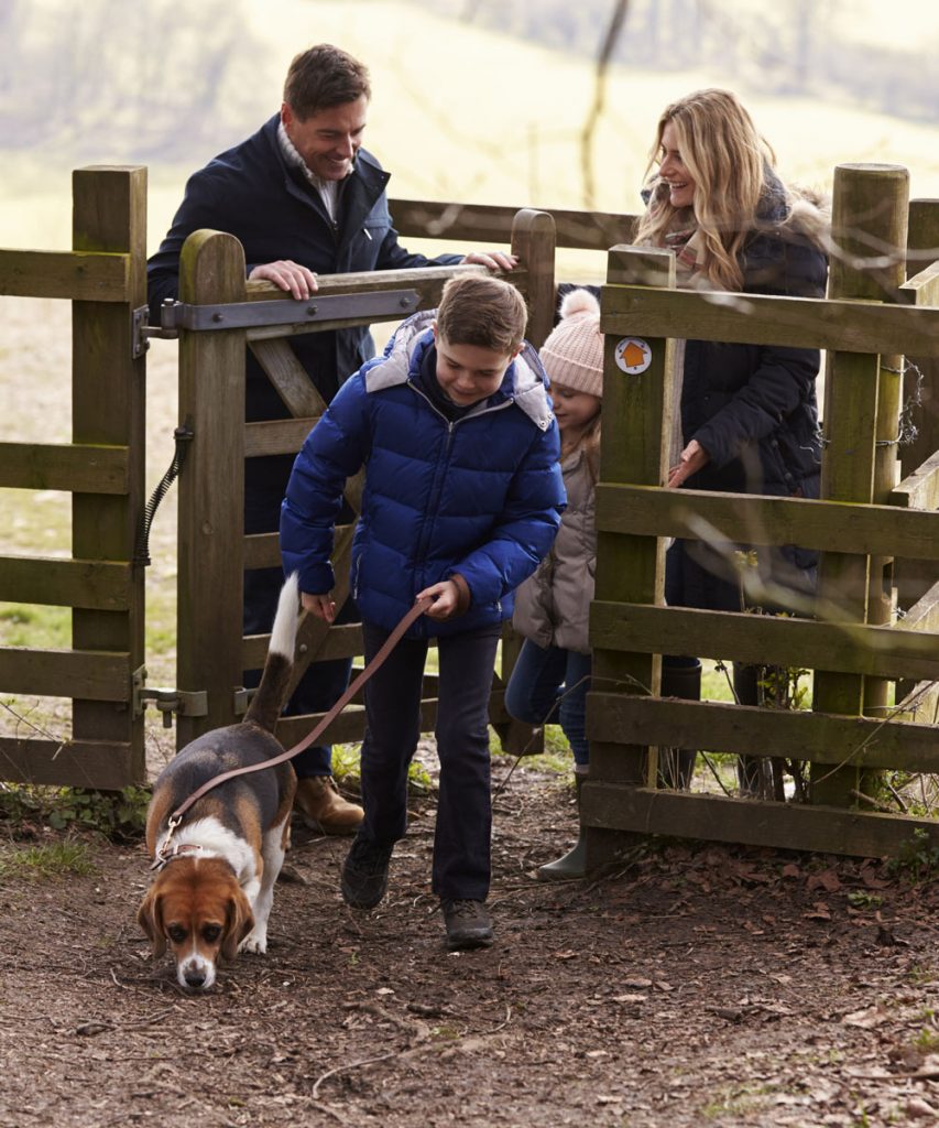 family of four entering gate with their dog